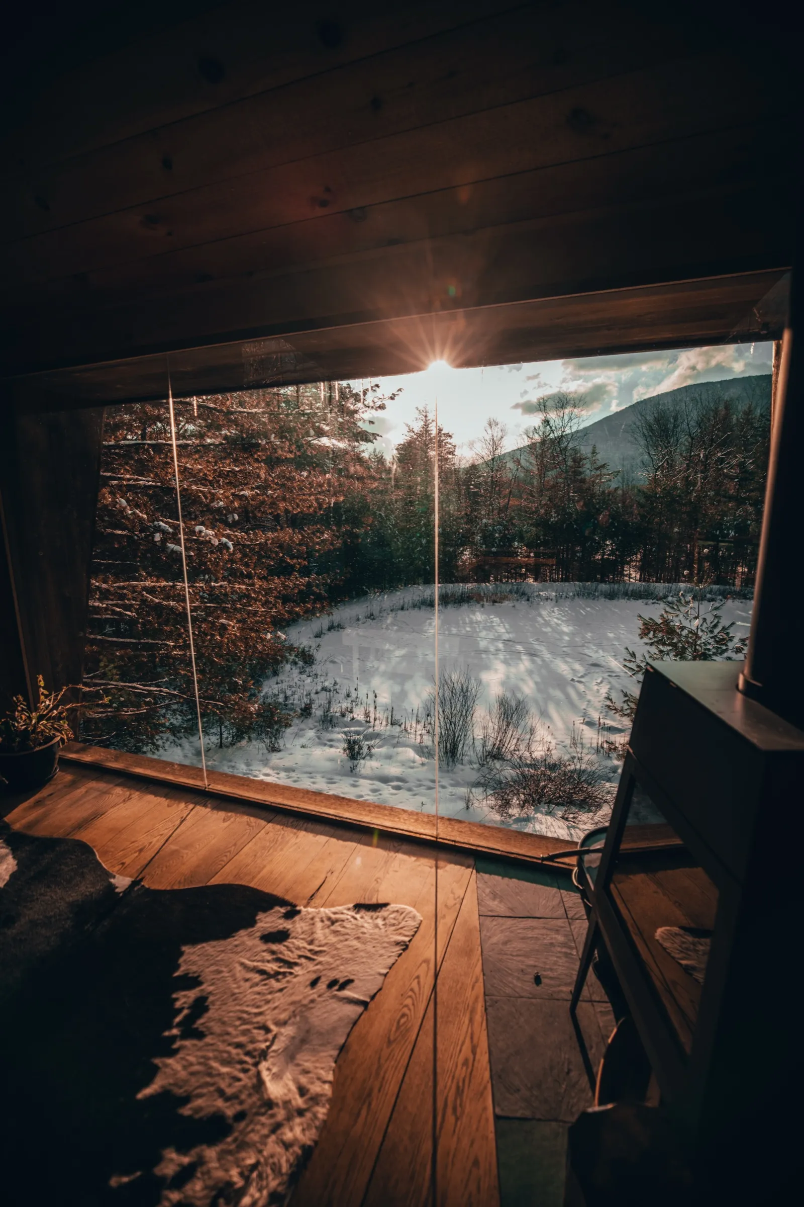 View through the glass walls at sunset over the frozen pond
